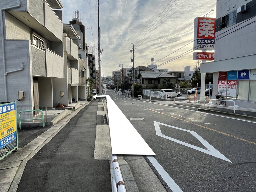 右手にドラッグユタカ八事天道店が見える通り。矢印は鋭角に左折